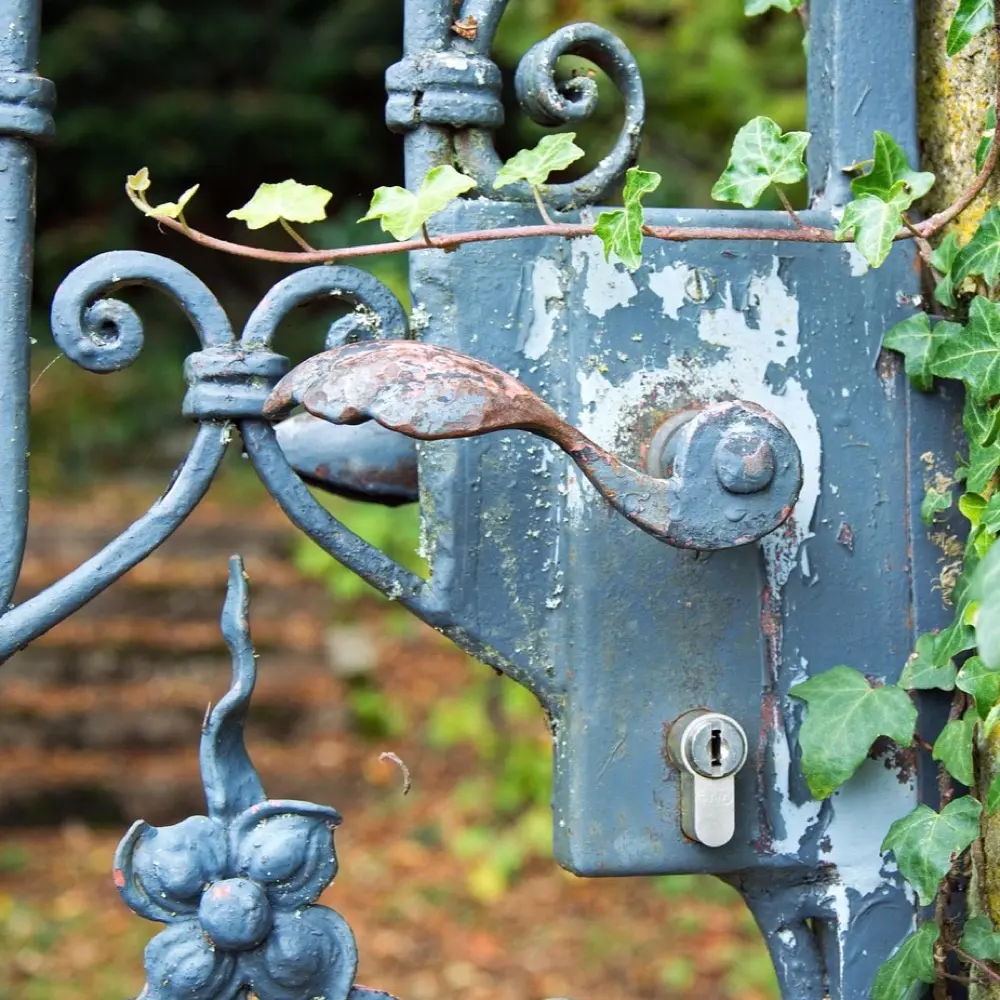 Een metalen tuinpoort met een poortslot en klink